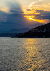Sunset over Mediterranean Sea Nice Bay and Alpes mountains rocky coast offshore Saint-Jean-Cap-Ferrat resort town on Cap Ferrat cape at French Riviera in France