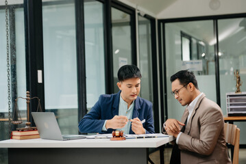 Business law concept, Lawyer business lawyers are consulting lawyers for man entrepreneurs to file copyright lawsuit with laptop and tablet at office