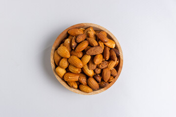 Almonds in wooden bowl. Almonds isolated on white background.