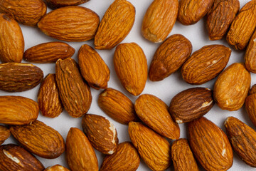 Almonds on white background. Raw peeled almond nuts texture