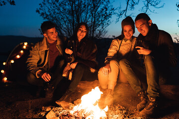 In forest, night time, four best friends are sitting by fire and having a good talk. They are...