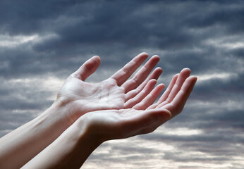 The outstretched hands of a praying man