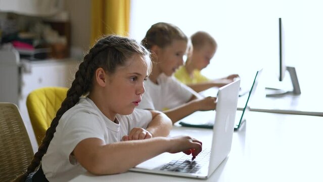 Group of children at school online learning. Teamwork of children with laptop online learning as a team. Children learn together at school to work as team with laptop.Team learning at school in lesson
