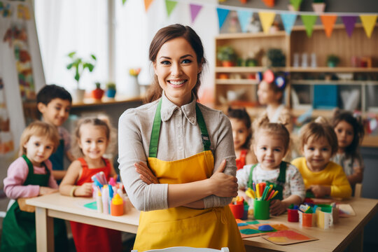 Teacher Looking At Camera With Her Students In The Background Smiling With Crossed Arms