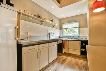 a kitchen with white cabinets and black counter tops in the center of the photo is taken from the front door