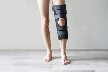 Man's knee with braces orthosis splint close up