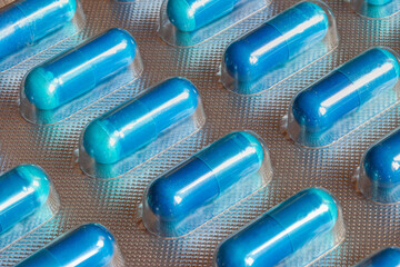 Blue medicine tablet in blister pack, close up.