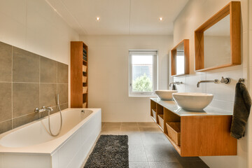a bathroom with wood cabinets and a white bathtub on the floor in front of the tub, sink and mirror