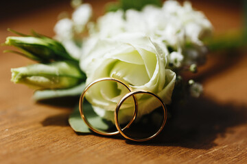 Yellow gold wedding rings. Closeup wedding jewelry. Metal rings on wooden table. Getting ready to...