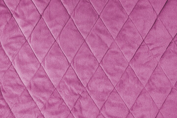 Quilted velours fabric background. Pink texture blanket or puffer jacket, stiched with diamond...