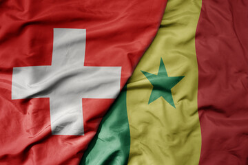 big waving national colorful flag of switzerland and national flag of senegal .