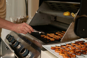 man frying shrimp on a gas grill