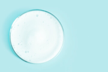 Washing agent foam in a Petri dish. On a green background.