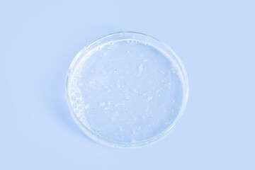 Facial Detergent in a Petri dish on a blue background.