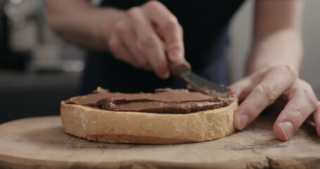 Man spreading chocolate paste on white bread