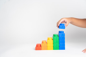 Kid hand put the colorful plastic building block toy