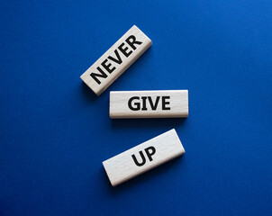 Never give up symbol. Concept words Never give up on wooden blocks. Beautiful deep blue green background. Business and Never give up concept. Copy space.