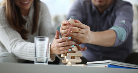 Obraz premium Focus on wooden tabletop board game. Worried people spending quality time with close friend or relative. Warm lovely evening concept. Blurred background