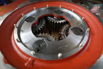 Big mechanical gear part with set of cogwheels inside close-up