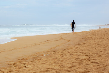Fototapeta na wymiar Surfer walking on the beach