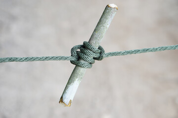 Close up rope knot tied on wooden stick. Concept, useful tying knot for various purposes in daily...