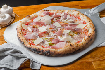 Pizza with salami, ham, jamon and Parmesan.