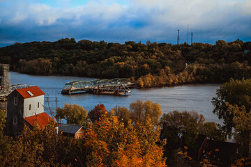 unfinished bridge over the river in little town with fall colors