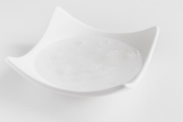 Transparent cosmetic gel in a white bowl.