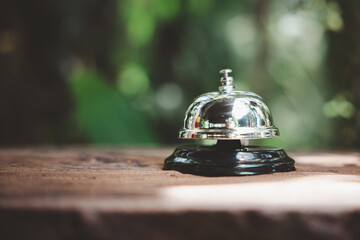 Hotel ring bell. Closeup of silver service restaurant bell on wooden counter desk, vintage bell to...