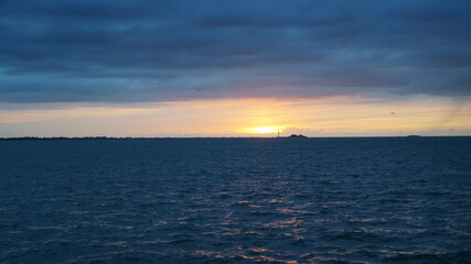 Fototapeta na wymiar The sun sets behind the horizon and the sea ends at the horizon line