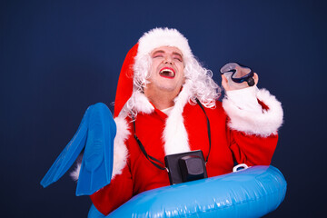 Summer and holidays at sea. A funny drag queen enjoys life in a Santa Claus costume. Blue background.