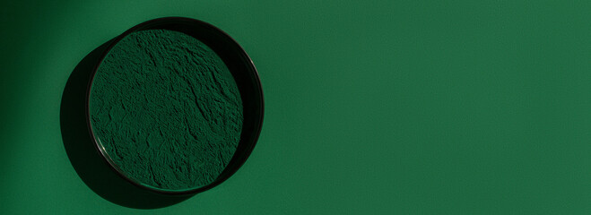 Fresh spirulina algae powder on green background, organic spirulina powder