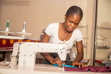 african tailor working in her shop