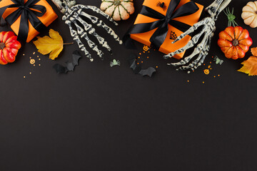 Don't miss out on our Halloween specials. Top view photo of skeleton hands, orange gift boxes, pumpkins, scary decorations, autumn leaves on black background with space for promotion or content