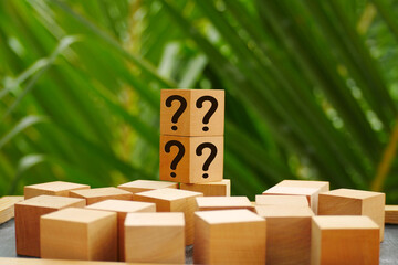 Three wooden cubes with a question mark over a beautiful bokeh nature background. Trouble and...