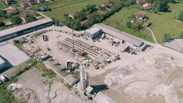 Construction material elements beams building site Manufacturing concrete beams storage. Aerial drone shot orbiting a factory warehouse where construstion material is stored and built. Sand, gravel
