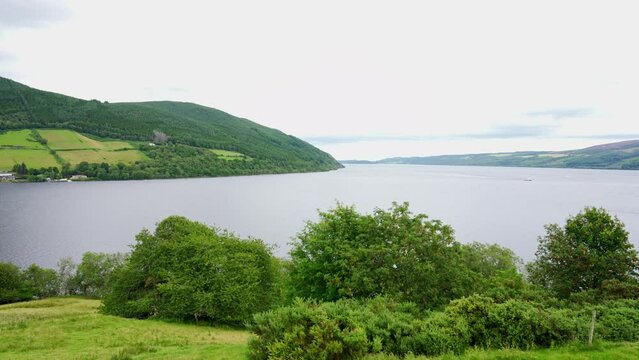 Green landscape of Loch Ness with the mountains surrounding the loch full of trees and meadows, Scotland