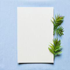 Happy birthday, mother's day, wedding composition. Blank greeting card, invitation and envelope mockup. Rectangular blank with fresh green leaves. Flat lay, top view.  Square.