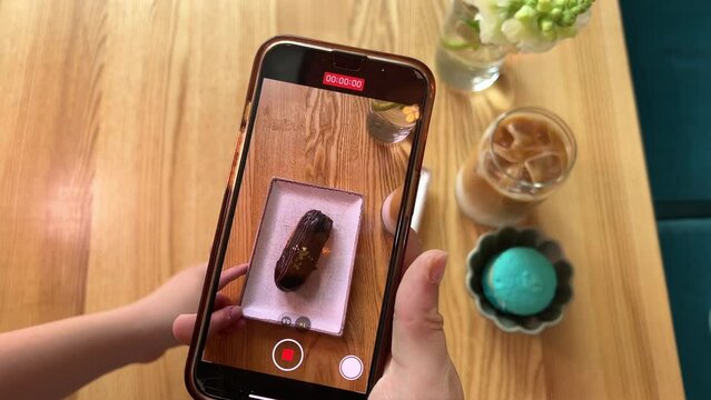 filming a cake in a restaurant with your phone, displaying your food in stories in Reelz, delicious, wonderful, interesting, adolescence, social networks, Internet, wi-fi, showing off with friends