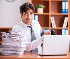 Young handsome businessman unhappy with excessive work