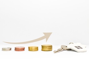 An increasing amount of money with an arrow showing a graph, ending with a key and a house pendant....