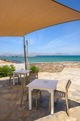 Tables and chairs overlooking the beach and sea on the island of Kos. Mastichari village.