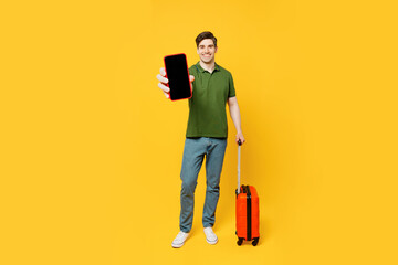 Traveler man wear casual clothes hold suitcase blank screen mobile cell phone isolated on plain...