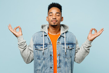 Young spiritual man of African American ethnicity wear denim jacket orange t-shirt hold spread...