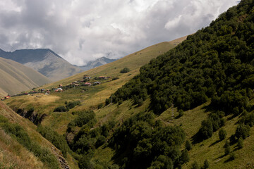 Picturesque view of the highest mountain settlement in Juta in Georgia located on green forest hills  on a sunny cloudy day in autumn