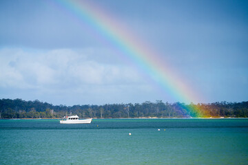 rainbow over the ovean and above an island in australia in summer