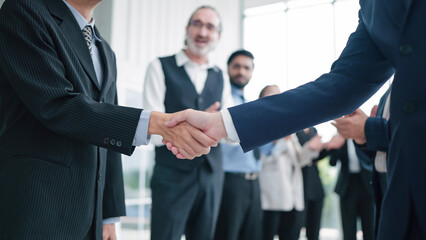 Close up shaking hands of business people close deal making agreement after successful meeting. Business partners shake hands. Business workers clapping hands on background. Partnership concept