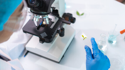 Close up scientist wearing glassware working with microscope for research and analysis experiment medical biotechnology medicine pharmaceutical healthcare