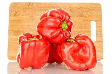 Four red sweet peppers with bamboo kitchen board, macro, isolated on white background.