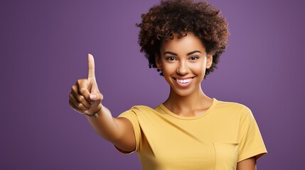 Positive Afro American woman pointing index finger up. Number one sign